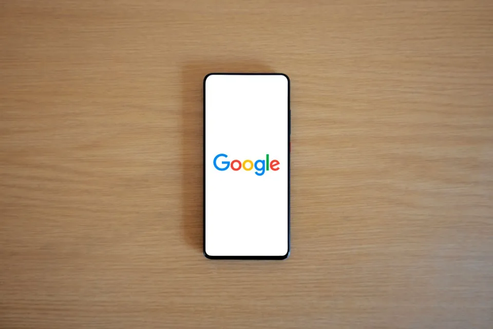 Celular em mesa com tela de busca para pesquisa de marca
